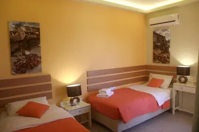 a bedroom with two beds and a mirror at Effi Apartments in Plataniás