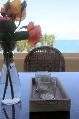 a table with a vase with flowers and two glasses at Effi Apartments in Plataniás