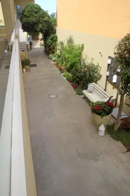 a walkway with a bench and plants in a building at Effi Apartments in Plataniás