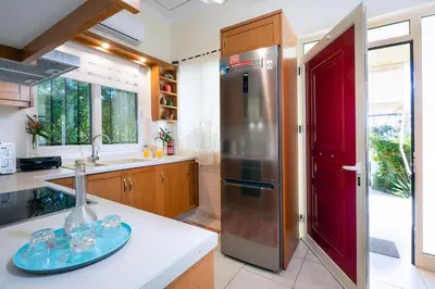a kitchen with a refrigerator and a red door at Niki House in Chania Town