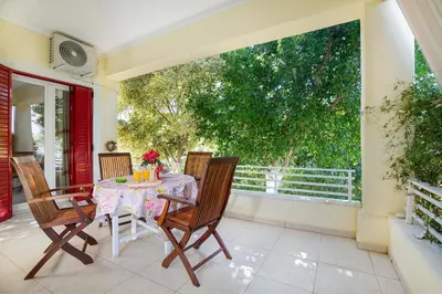 a table and chairs on a patio with a window at Niki House in Chania Town
