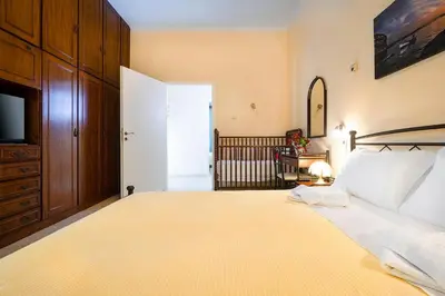 a bedroom with a large bed and a television at Niki House in Chania Town