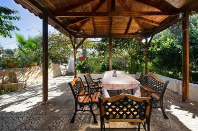 a table and chairs under a wooden pergola at Niki House in Chania Town