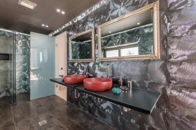 a bathroom with two red sinks on a black counter at Villa Kounoupidiana in Kounoupidhianá