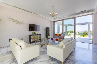 a living room with two white couches and a tv at Villa Kounoupidiana in Kounoupidhianá