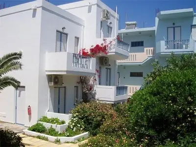 a white building with balconies and flowers on it at Santa Irene in Sougia