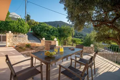 a wooden table and chairs on a patio at Panorama Country Residence in Tzitzifés