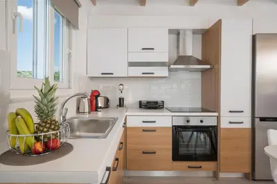 a kitchen with a sink and a bowl of fruit at b&m villas in Metókhion Sirilíou