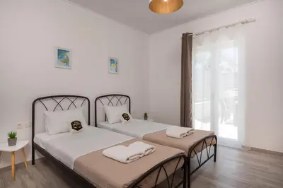 two beds in a room with white walls at b&m villas in Metókhion Sirilíou