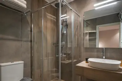 a bathroom with a toilet and a sink and a shower at Plaza 1866 Superior City Rooms in Chania Town