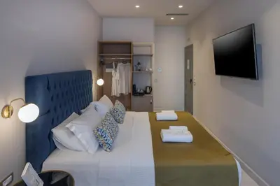 a living room with a couch and a flat screen tv at Plaza 1866 Superior City Rooms in Chania Town