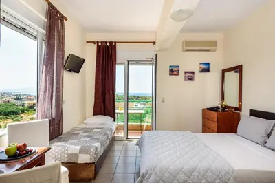 a hotel room with two beds and a balcony at Golden Beach Hill Apartments in Kato Daratso