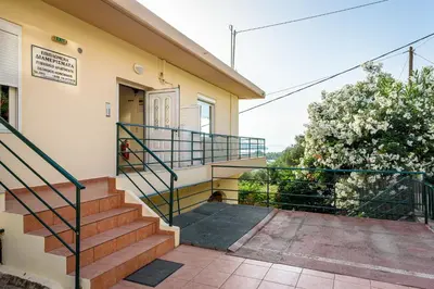 a house with a staircase leading to the front door at Golden Beach Hill Apartments in Kato Daratso