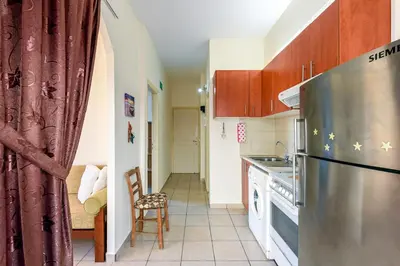 a kitchen with a stainless steel refrigerator and cabinets at Golden Beach Hill Apartments in Kato Daratso