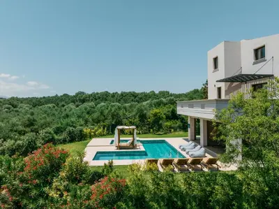an external view of a house with a swimming pool at Olvini Villa in Galatás