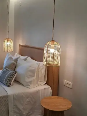 a bedroom with a bed with two lights and a table at Grammeno Seaside Studios in Palaiochóra