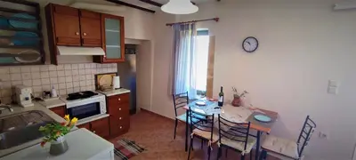 a kitchen with a table and a dining room at Villa Rosemari, Anatoli Apartment in Afráta