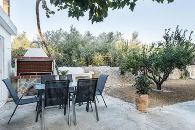a patio with a table and chairs and a grill at Anemelia in Chania Town
