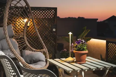 a patio table with a candle and flowers on a balcony at Lignum Suites Chania in Chania Town