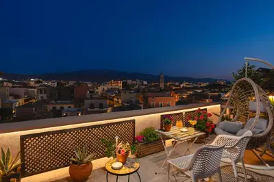 a balcony with chairs and tables and a view of a city at Lignum Suites Chania in Chania Town
