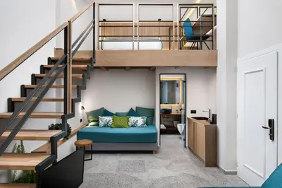 a living room with a blue couch under a staircase at Lignum Suites Chania in Chania Town