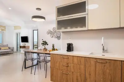 a kitchen with wooden cabinets and a table with chairs at Magnolia Luxury Apartments in Falasarna