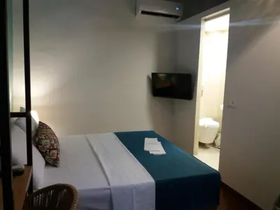 a bedroom with a bed with a blue blanket and a television at Fivos Residence in Chania Town