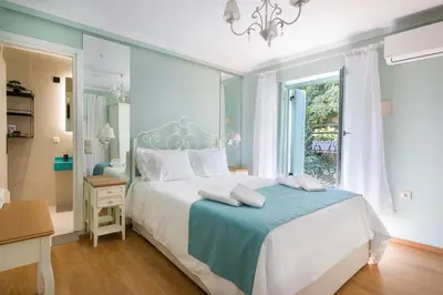 a bedroom with a blue and white bed and a window at Iosifinas Boutique House in Chania Town