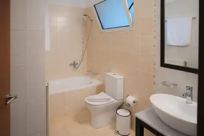 a bathroom with a toilet and a sink at Sweven Villa Private Pool & Absolute Privacy , Stunning Sunsets in Souda