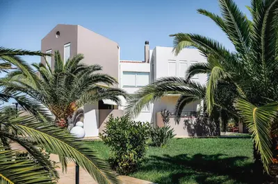 a house with palm trees in front of it at Sweven Villa Private Pool & Absolute Privacy , Stunning Sunsets in Souda