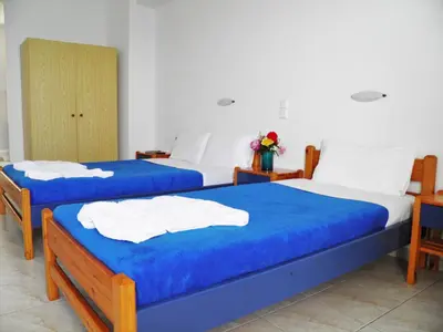 two beds in a room with blue and white at Christi Apartments in Kalyves