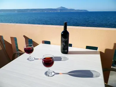 a bottle of wine sitting on a table with two glasses at Christi Apartments in Kalyves