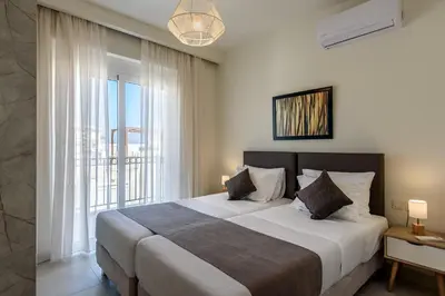 a bedroom with a large bed and a large window at Azure Beach Villas in Kissamos