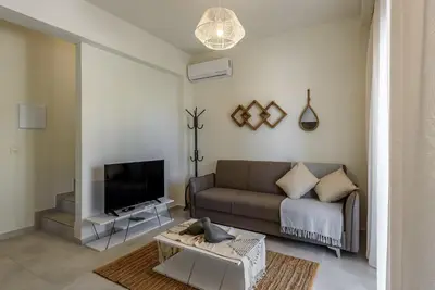 a living room with a couch and a tv at Azure Beach Villas in Kissamos