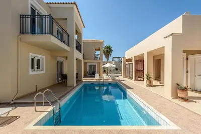 a swimming pool in a villa with a house at Azure Beach Villas in Kissamos
