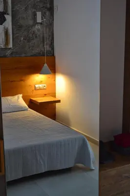 a bedroom with a bed and a table and a lamp at Paraskevi's Apartments in Kissamos