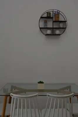 a dining room table with two chairs and a mirror at Paraskevi's Apartments in Kissamos