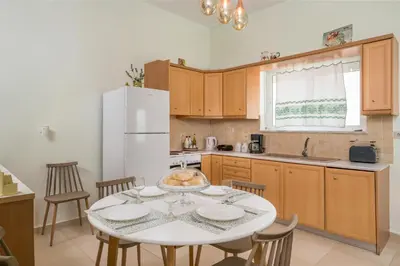 a kitchen with a table and a white refrigerator at OLIVE BREEZE in Kissamos