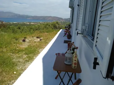 a balcony with two tables on the side of a house at OLIVE BREEZE in Kissamos