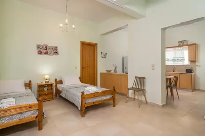 a bedroom with two beds and a kitchen at OLIVE BREEZE in Kissamos