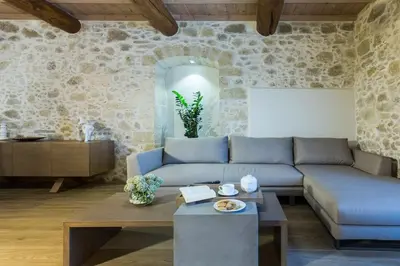 a living room with a blue couch and a table at Kamartsos Villa 2 in Áyios Yeóryios