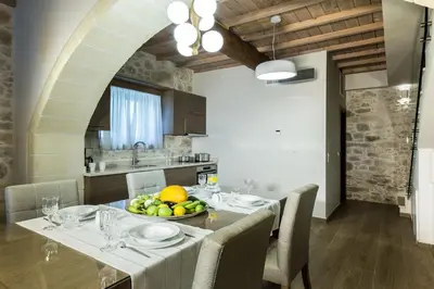 a kitchen with a table with a bowl of fruit on it at Kamartsos Villa 2 in Áyios Yeóryios