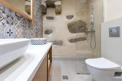 a bathroom with a shower and a toilet and a sink at Stairs Homes & Suites in Kamária
