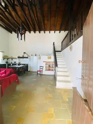 a living room with a staircase and a table at The Green Home in Afráta