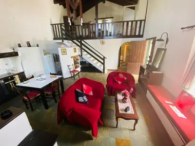 a living room with two red chairs and a table at The Green Home in Afráta