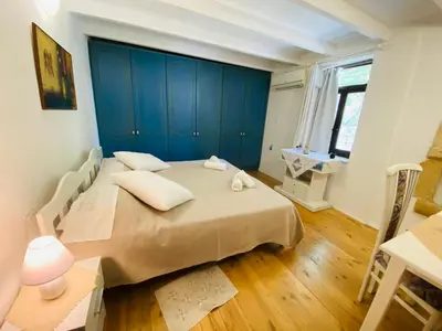 a bedroom with a large bed and a blue wall at The Green Home in Afráta