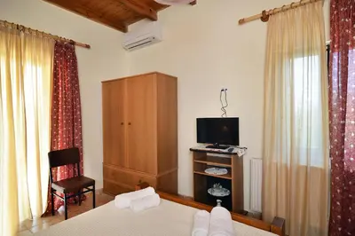 a bedroom with a bed and a tv and a cabinet at Raphael Evangellos Villa in Gavalochori