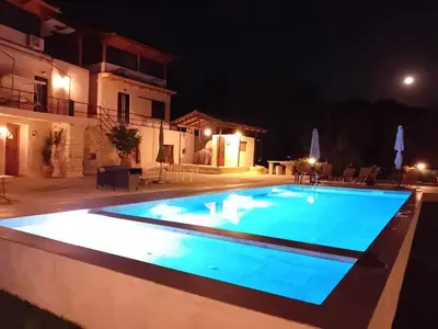 a swimming pool at night with lights on it at Raphael Evangellos Villa in Gavalochori