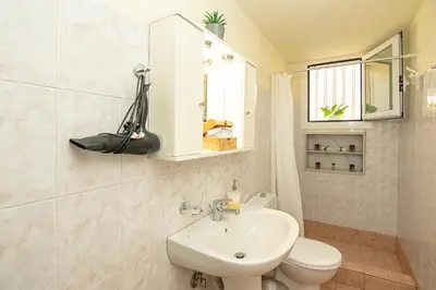 a bathroom with a sink and a toilet and a mirror at Veranda house in Chania Town