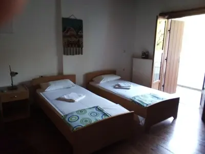two beds in a small room with a window at Therisso Rooms in Thérison